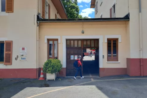un jeune de dos qui entre dans le bâtiment