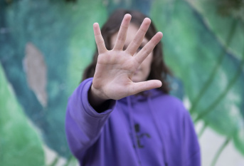La main d'un jeune garçon devant son visage, flouté en arrière plan