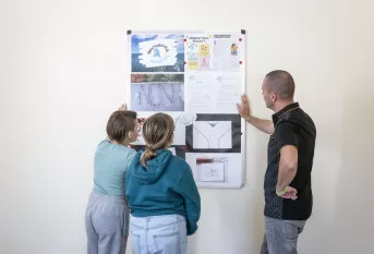 2 jeunes et le responsable sentinelle devant les affiches qui représentent le harcèlement scolaire