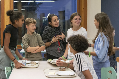 Un groupe de jeunes en disussion avec l'éducatrice pastorale à la fin de leur diner au self